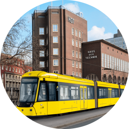 Fotomontage einer gelben Straßenbahn, die vor dem "Haus der Technik" in Essen vorbeifährt.